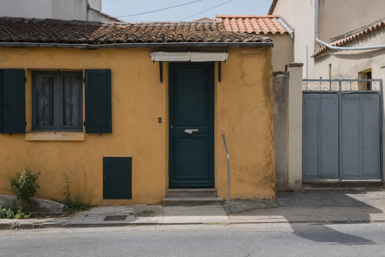 Porte d’entrée fermée d’une maison du Midi vue de la rue, prospectus sans en-tête coincé dans la boîte aux lettres